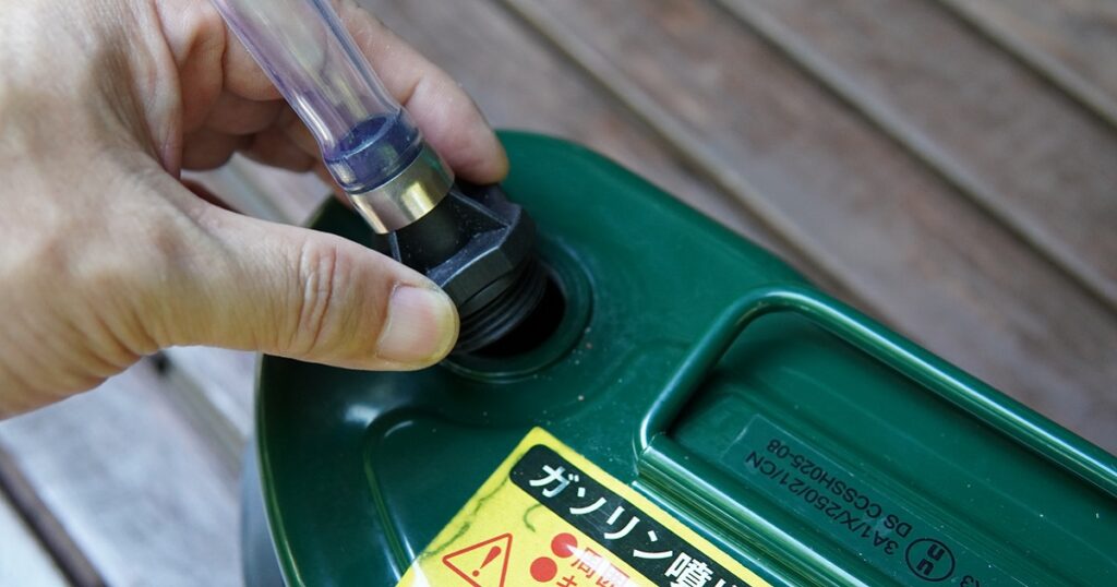 携行缶の給油準備：給油キャップを開けて、給油ノズルに付け替える。